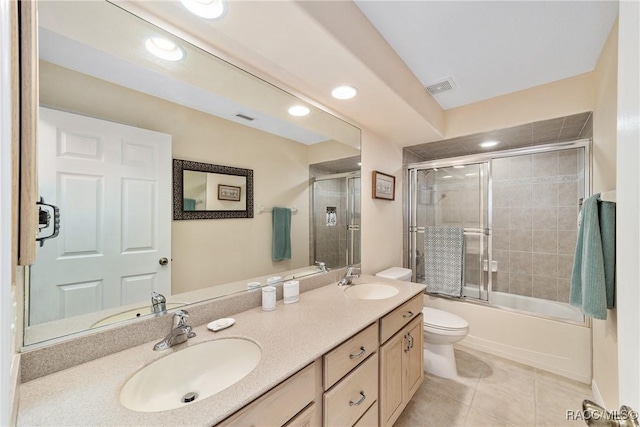 full bathroom with bath / shower combo with glass door, tile patterned floors, vanity, and toilet