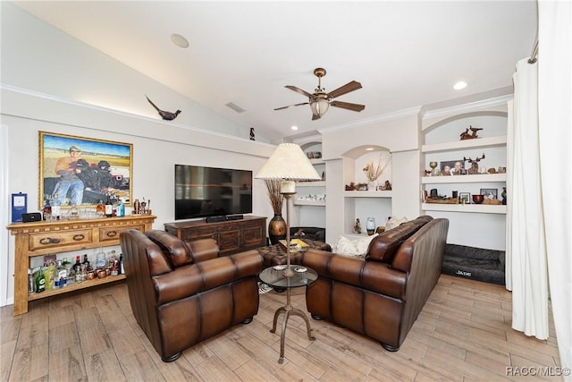 living room with ceiling fan, built in shelves, vaulted ceiling, and light hardwood / wood-style flooring