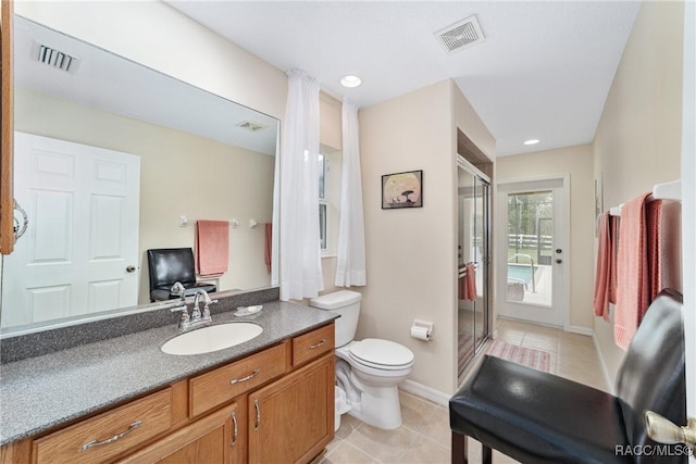 bathroom with tile patterned floors, vanity, toilet, and walk in shower