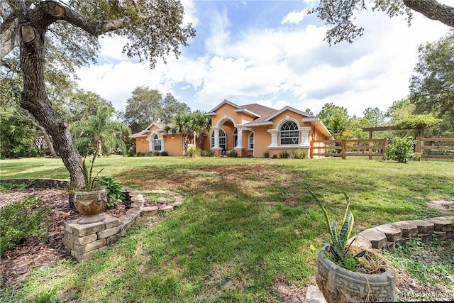 mediterranean / spanish house featuring a front lawn