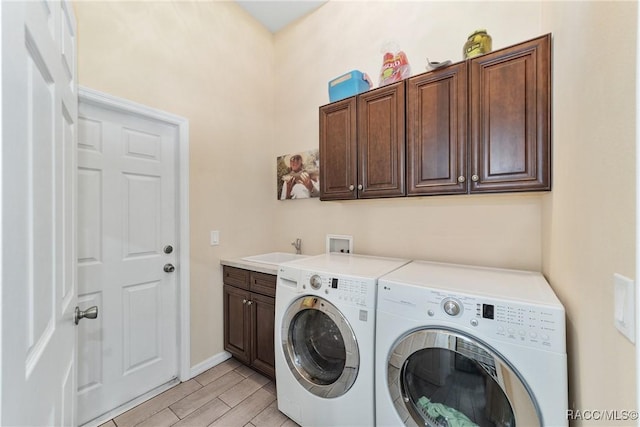 laundry room with washer and dryer, cabinets, and sink