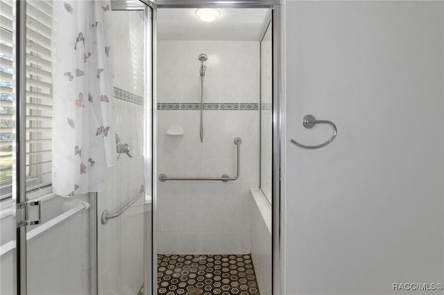 bathroom featuring a shower with shower door