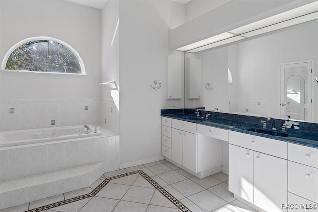 bathroom featuring vanity, a relaxing tiled tub, and tile patterned floors