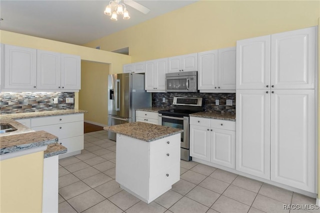 kitchen with stainless steel appliances, white cabinetry, a center island, and light tile patterned floors