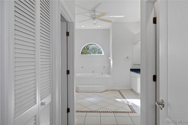 bathroom featuring tile patterned flooring, vanity, a relaxing tiled tub, and ceiling fan