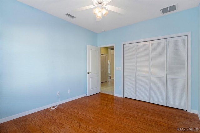 unfurnished bedroom with wood-type flooring, a closet, and ceiling fan