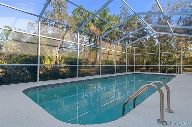 view of swimming pool with glass enclosure and a patio area