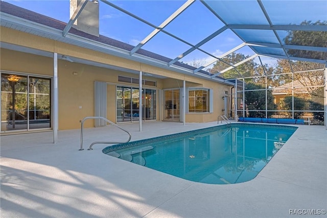 view of swimming pool with glass enclosure and a patio