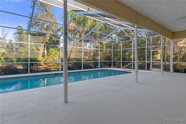 view of swimming pool with a patio area and glass enclosure