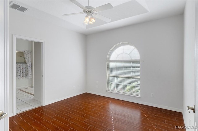 spare room with ceiling fan and a tray ceiling