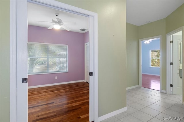 hallway featuring light wood-type flooring and a wealth of natural light