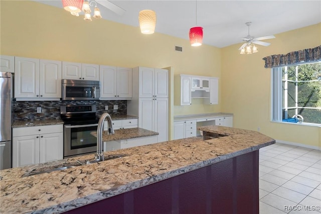 kitchen featuring ceiling fan with notable chandelier, kitchen peninsula, light hardwood / wood-style flooring, appliances with stainless steel finishes, and white cabinetry