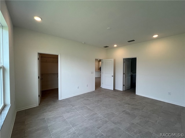 unfurnished bedroom featuring a spacious closet and a closet