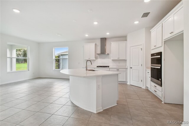 kitchen featuring white cabinets, stainless steel appliances, and light tile patterned flooring