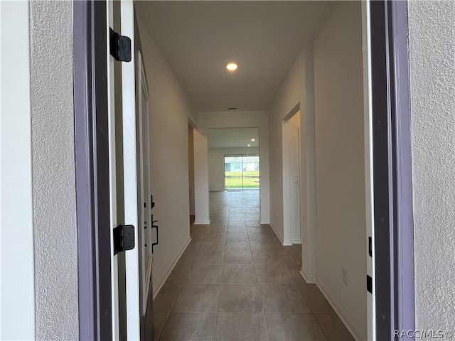 hall with light tile patterned floors