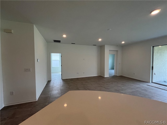 spare room with dark tile patterned floors