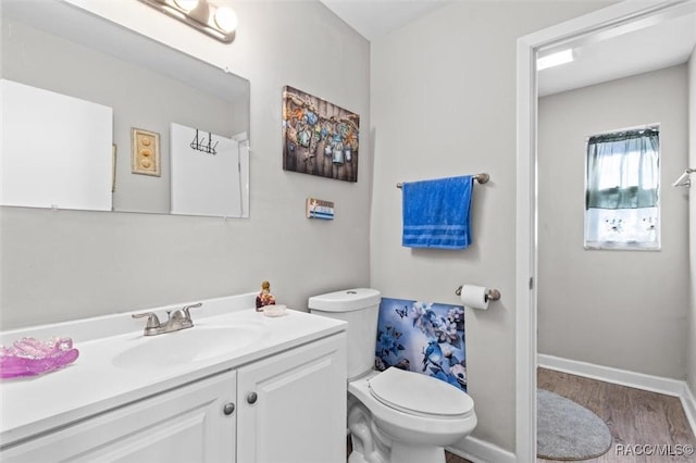 bathroom with hardwood / wood-style floors, vanity, and toilet