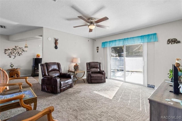 living room with carpet, a textured ceiling, and ceiling fan