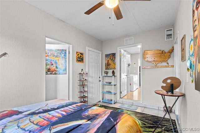 bedroom featuring washer / dryer, tile patterned floors, and ceiling fan