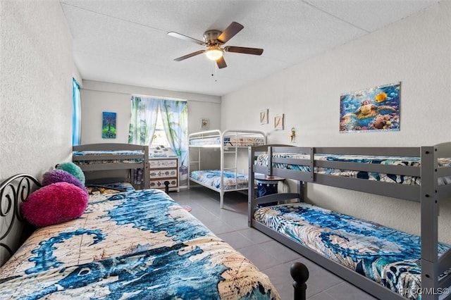 bedroom featuring ceiling fan, light tile patterned flooring, and a textured ceiling