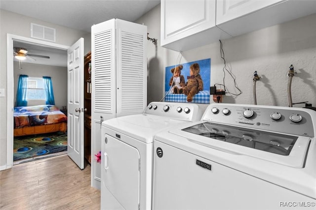 laundry room featuring ceiling fan, cabinets, independent washer and dryer, and light wood-type flooring