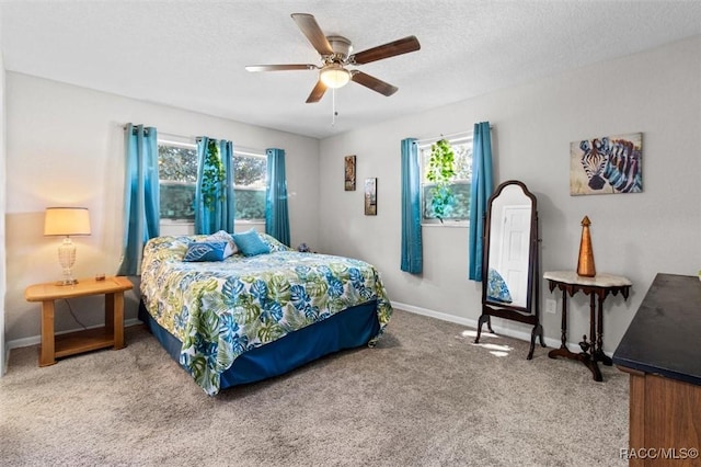 bedroom with multiple windows, ceiling fan, carpet, and a textured ceiling