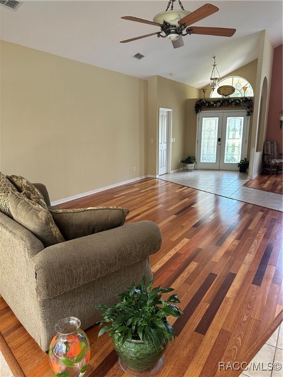 living room featuring wood-type flooring, vaulted ceiling, french doors, and ceiling fan