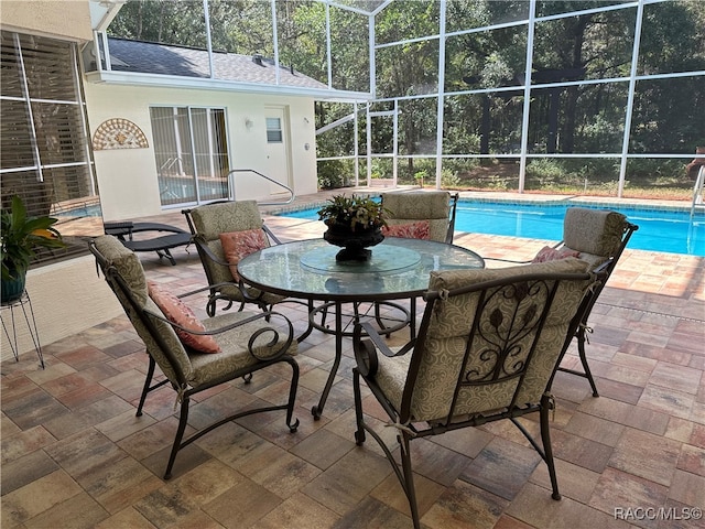 view of pool featuring glass enclosure and a patio