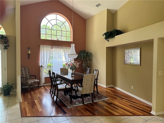 dining room featuring light hardwood / wood-style flooring and high vaulted ceiling