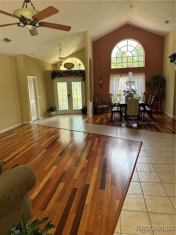 unfurnished dining area with hardwood / wood-style floors, french doors, ceiling fan, and lofted ceiling