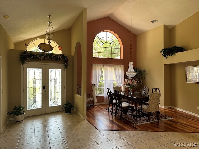 dining space with wood-type flooring, high vaulted ceiling, and a wealth of natural light