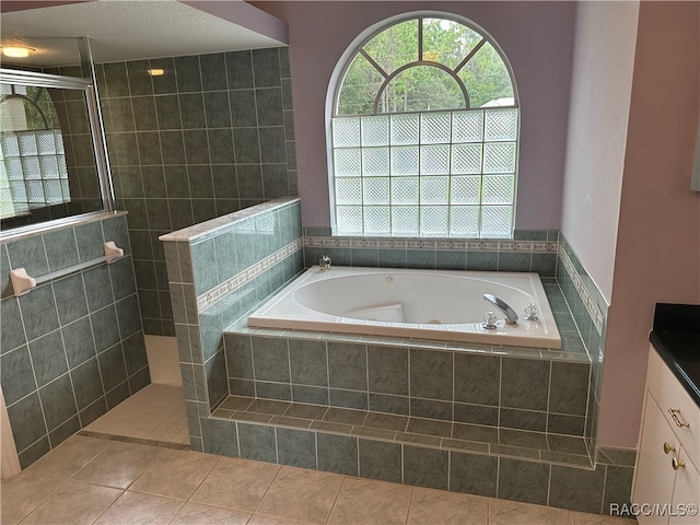 bathroom featuring separate shower and tub, tile patterned flooring, and a textured ceiling