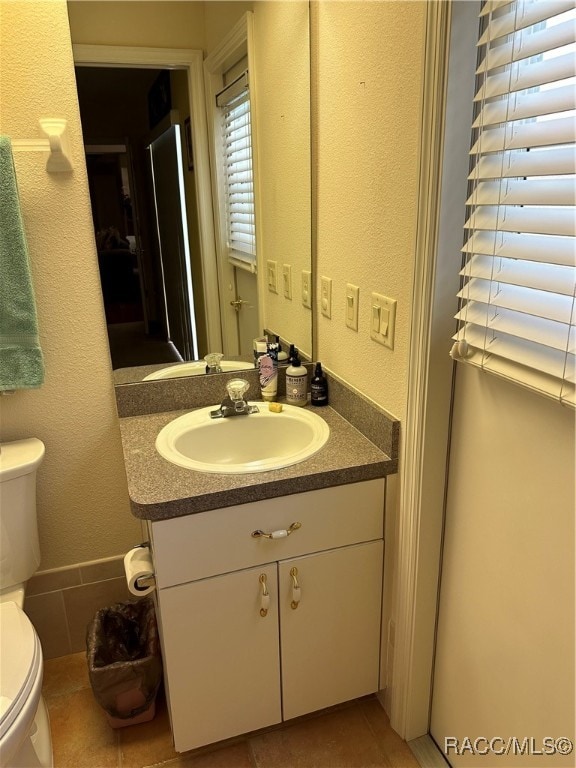 bathroom with tile patterned floors, vanity, and toilet