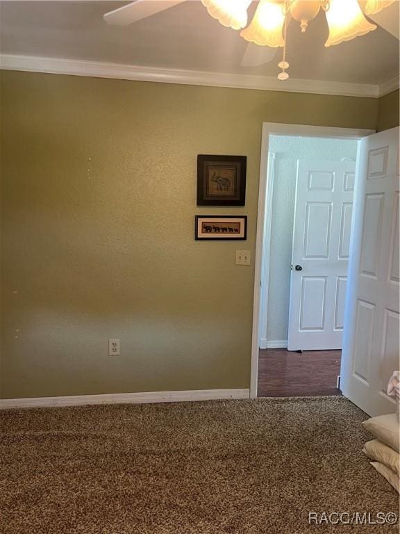 carpeted spare room with ceiling fan and crown molding