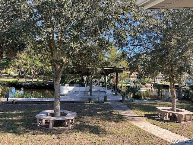 view of property's community with a water view and a lawn