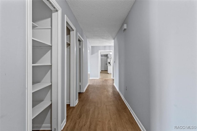 corridor featuring hardwood / wood-style floors and a textured ceiling