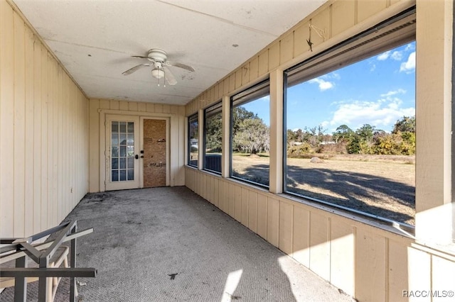 unfurnished sunroom featuring ceiling fan