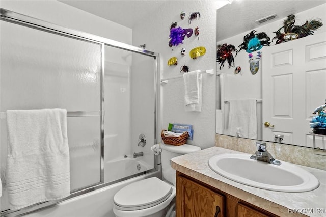 bathroom with visible vents, combined bath / shower with glass door, vanity, and toilet