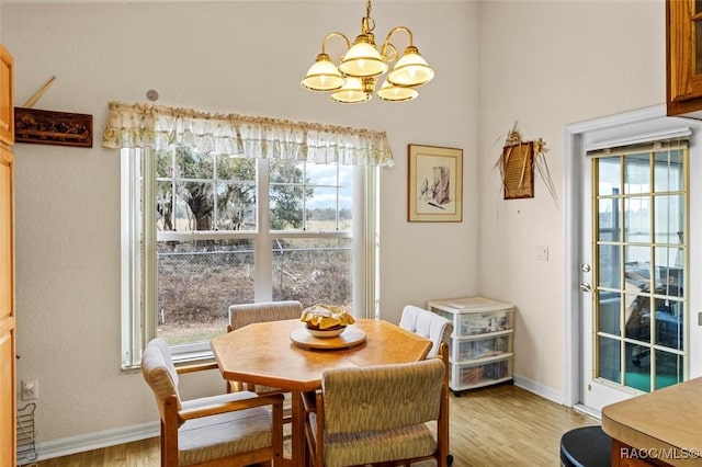 dining area with a chandelier, baseboards, a healthy amount of sunlight, and light wood finished floors