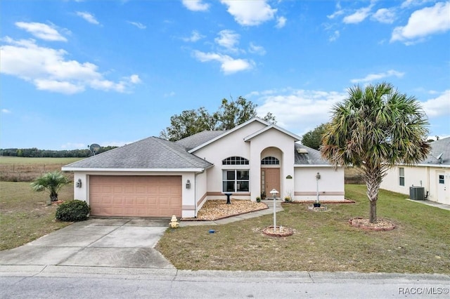 ranch-style home featuring concrete driveway, stucco siding, an attached garage, and central AC unit