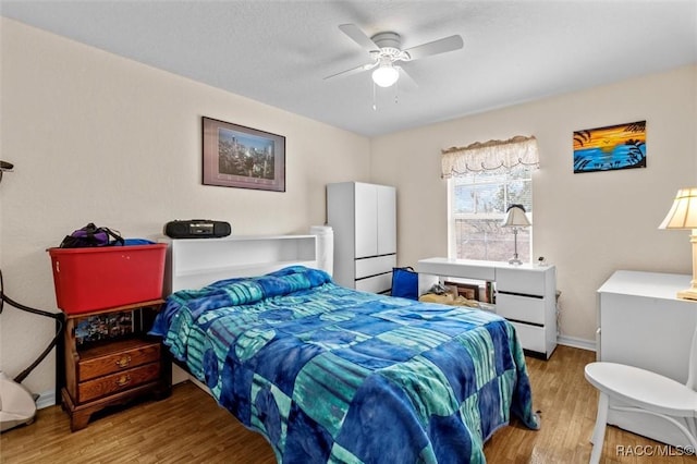 bedroom featuring ceiling fan, baseboards, and wood finished floors