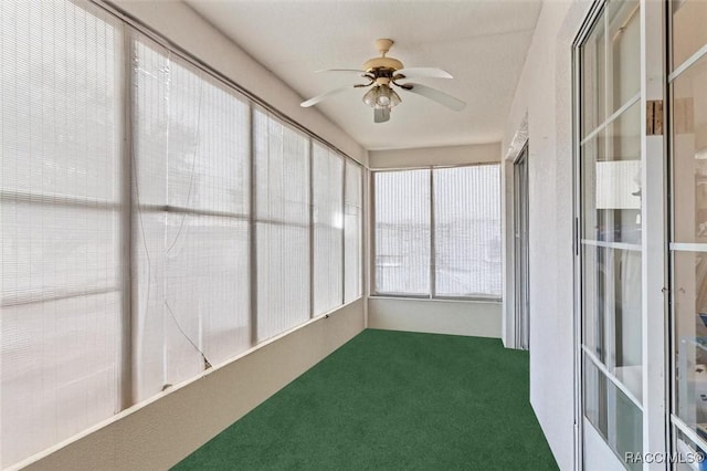 unfurnished sunroom featuring a ceiling fan