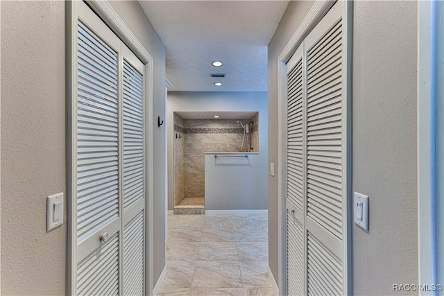 hall featuring recessed lighting and baseboards