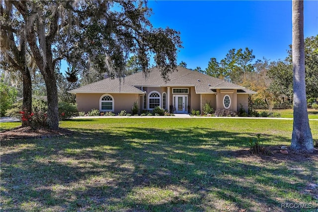 single story home featuring a front yard, french doors, and stucco siding