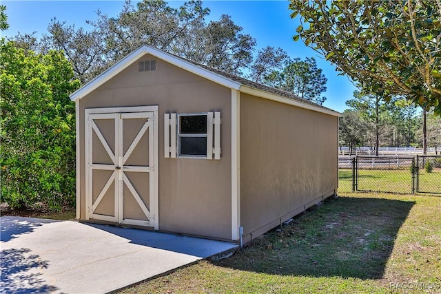 view of shed featuring a gate and fence