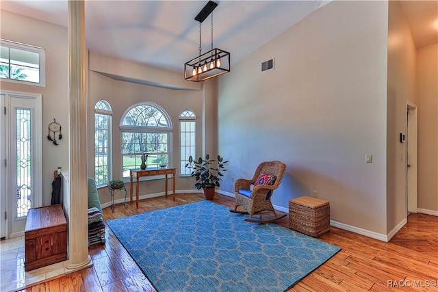 entrance foyer with a high ceiling, wood-type flooring, visible vents, and baseboards