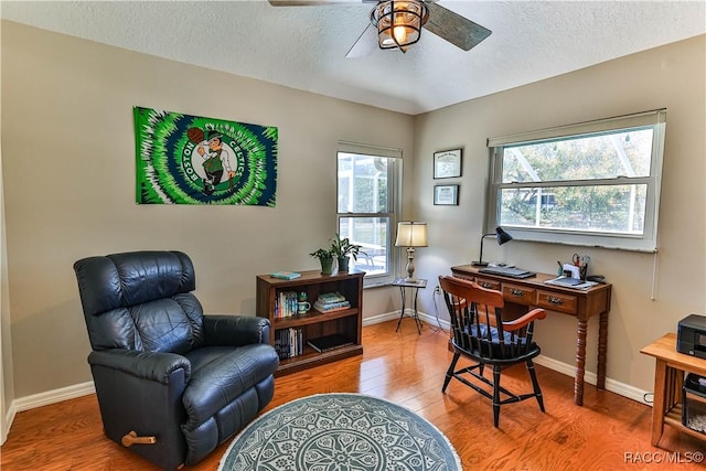 office featuring a textured ceiling, baseboards, and wood finished floors