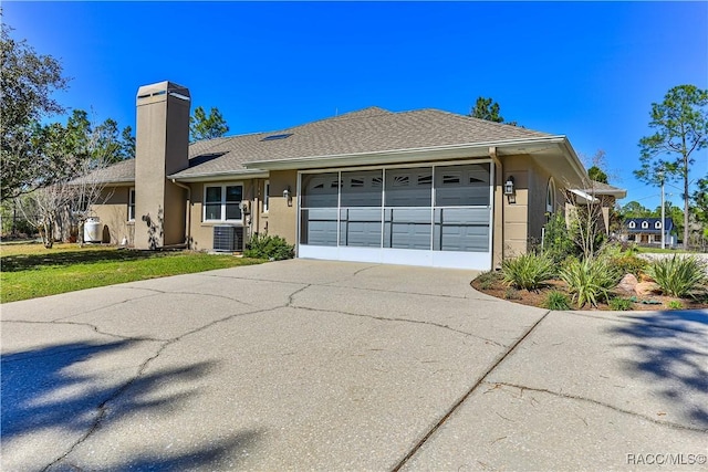 ranch-style home with roof with shingles, a chimney, stucco siding, a garage, and driveway