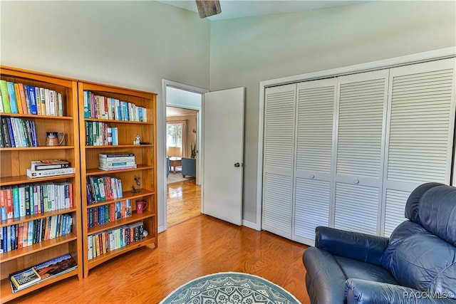 living area featuring high vaulted ceiling and wood finished floors