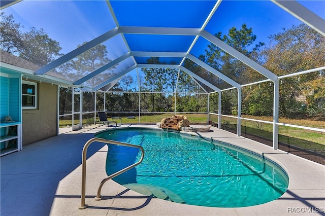 outdoor pool with glass enclosure and a patio area